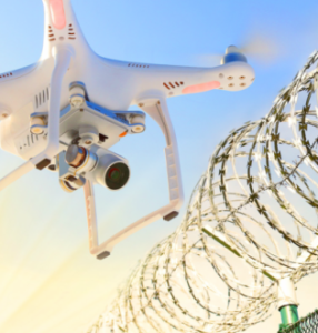 Drone with camera just outside a barbed wire fence