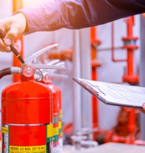 Fire risk assessment manager checking extinguisher
