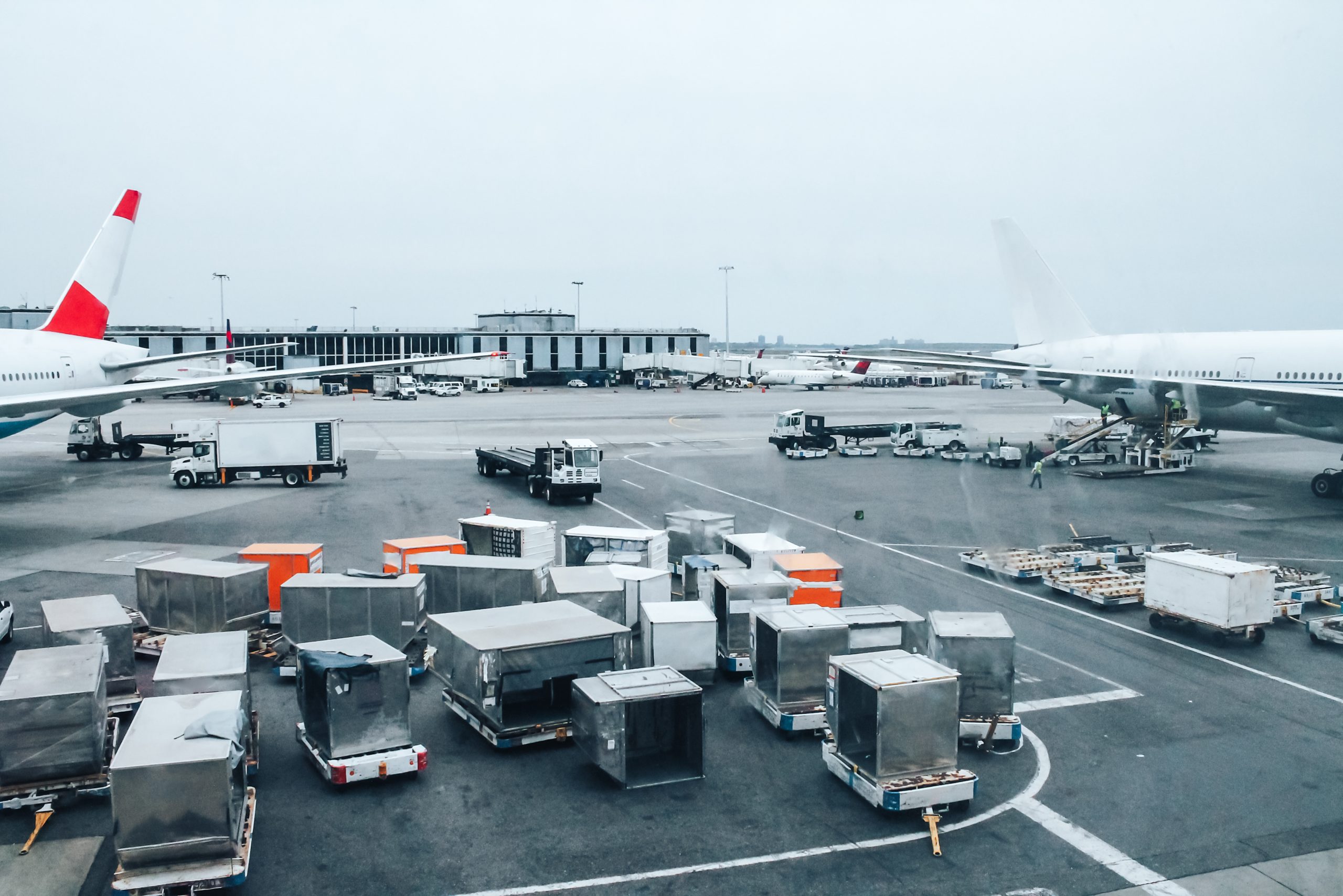 Large airport with cars, containers and planes