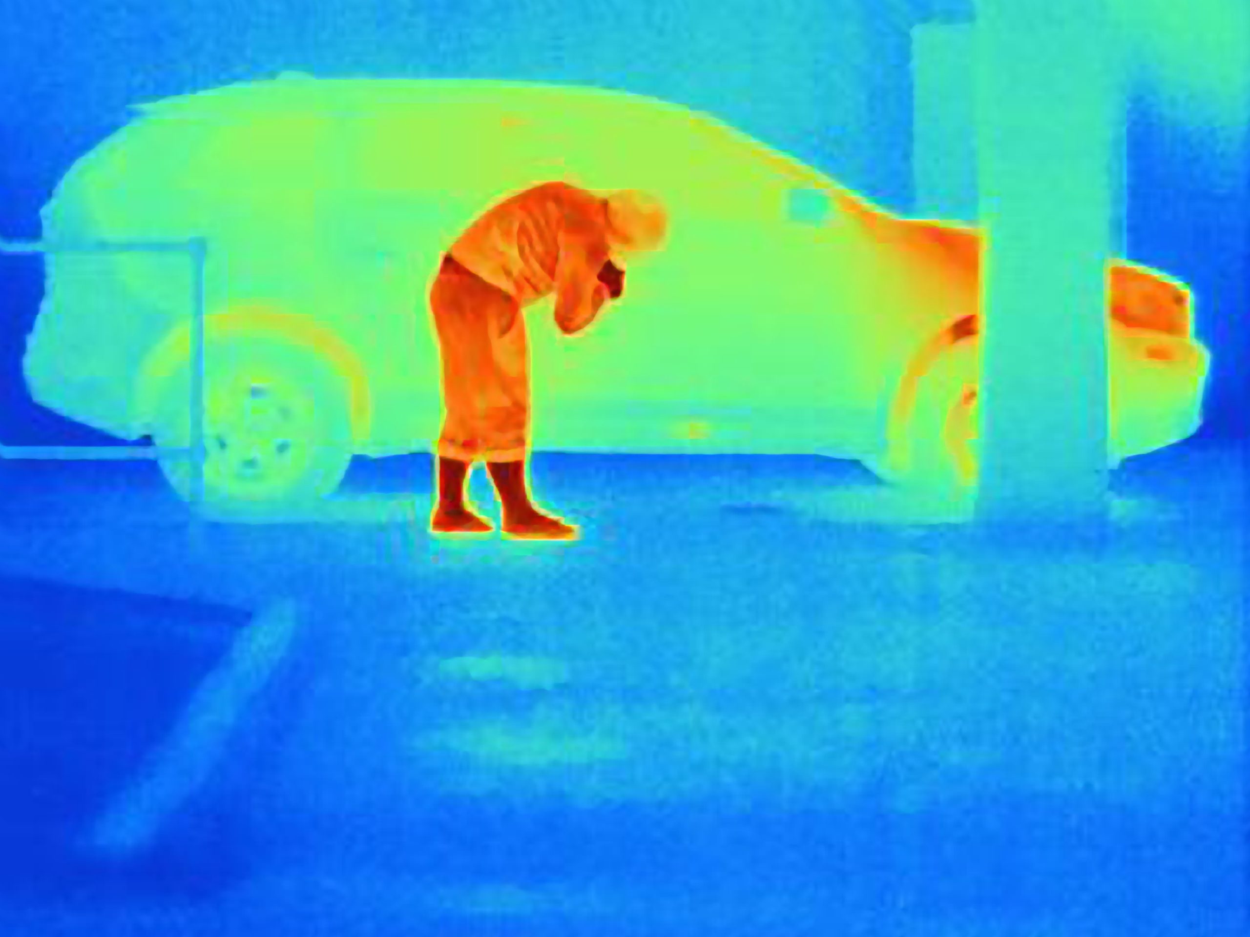 Thermal photograph of a burglar breaking into a car