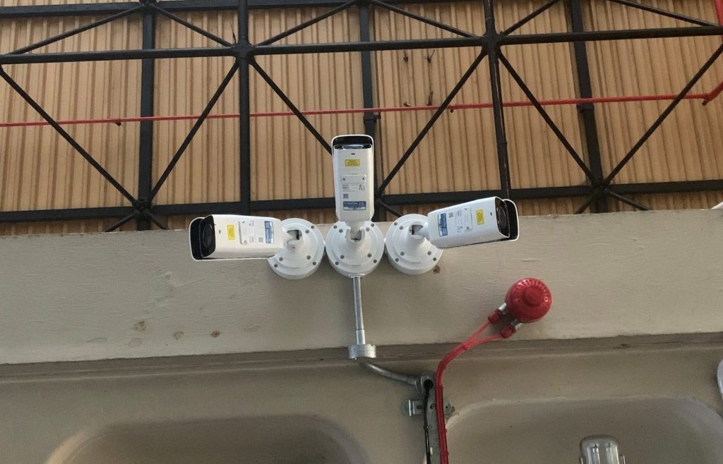 3 CCTV cameras installed on a ceiling next to a smoke detector